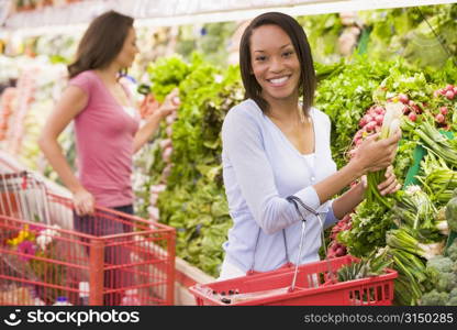 Women shopping for vegetables at a grocery store