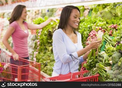 Women shopping for vegetables at a grocery store