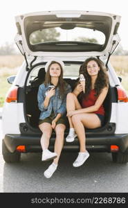 women sitting car with ice cream