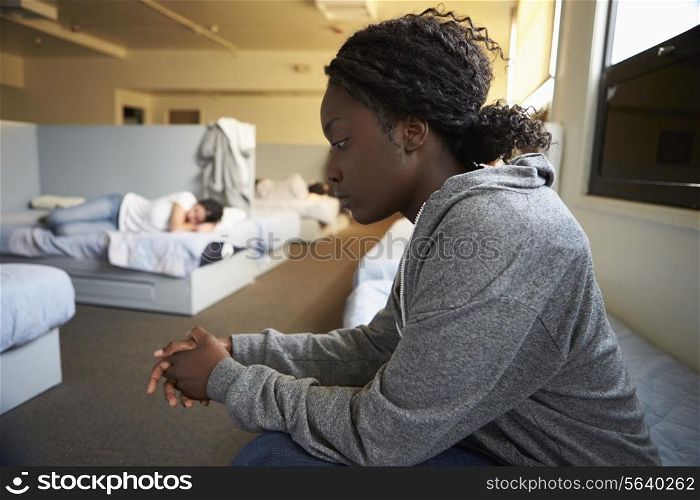 Women Sitting On Beds In Homeless Shelter
