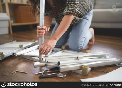 Women sitting on floor to assembling diy rack shelving furniture with manual labor for new house.