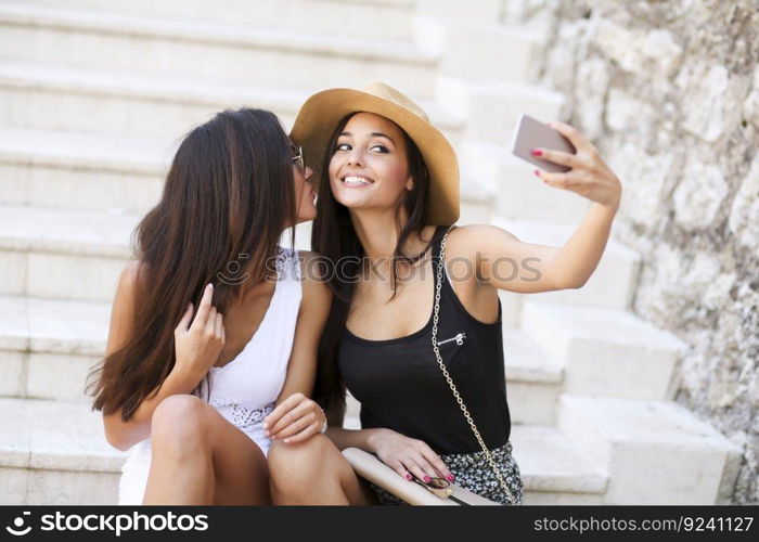 Women sitting on the stairs and taking selfie