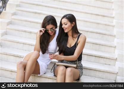 Women sitting on the stairs and taking selfie