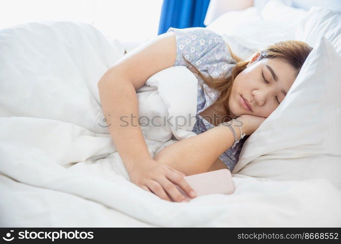 women sleeping in cozy white bed, Asian chubby young fat girl rest with cellphone.