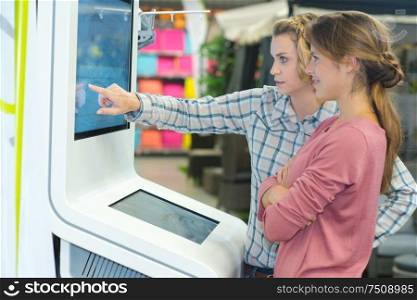 women standing front big digital screen
