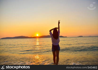 Women standing on beach at sea sunset background on evening golden hour.Travel summer holiday sea beach in Thailand