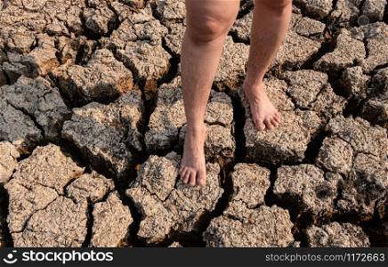 Women standing on cracked and dry soil in arid areas landscape, Drought crisis Concept