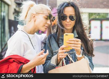 women sunglasses using smartphone