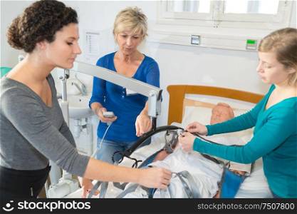 women trainging to use hoist over hospital bed