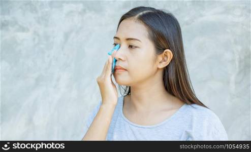 Women use oil remover paper on her face.