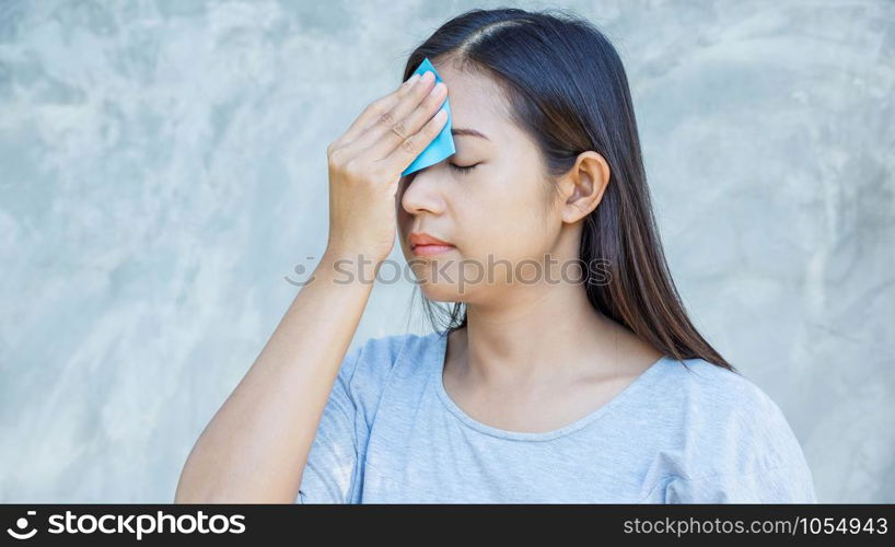 Women use oil remover paper on her face.