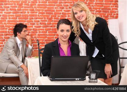 Women using a laptop in a restaurant