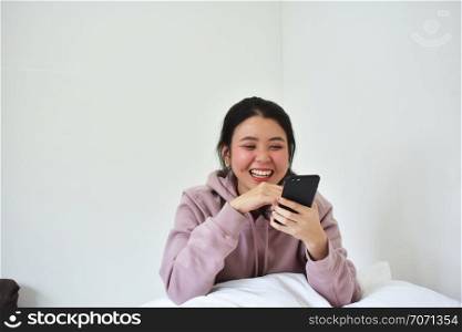 Women using mobile smartphone is ion bedroom