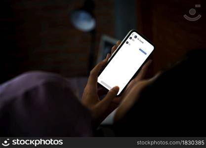 women using phone texting social on bed at night
