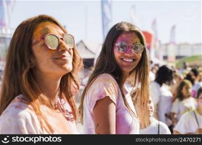 women wearing sunglasses with holi powder face