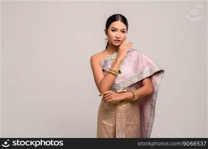 women wears Thai dress and hands touch the face.