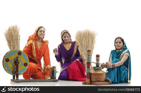 Women with a spinning wheel and a butter churner