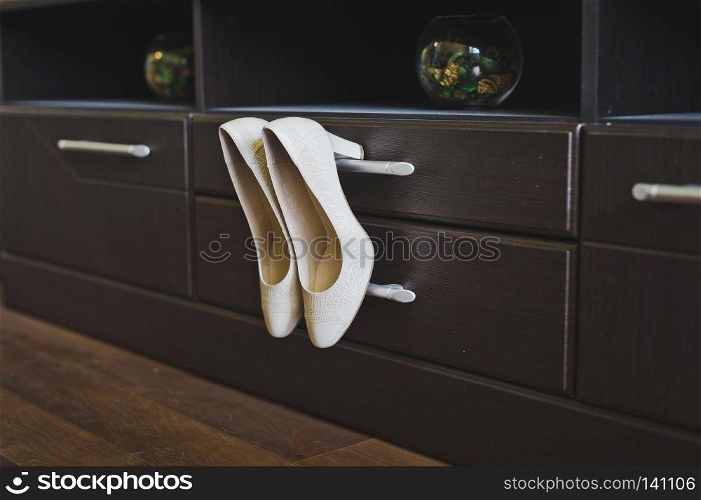 Womens shoes hanging in the closet.. White shoes Cabinet knob 6533.