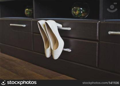 Womens shoes hanging in the closet.. White shoes Cabinet knob 6533.