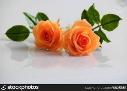 Wonderful clay art with orange roses flower relect on white background, beautiful artificial flowers of craftsmanship