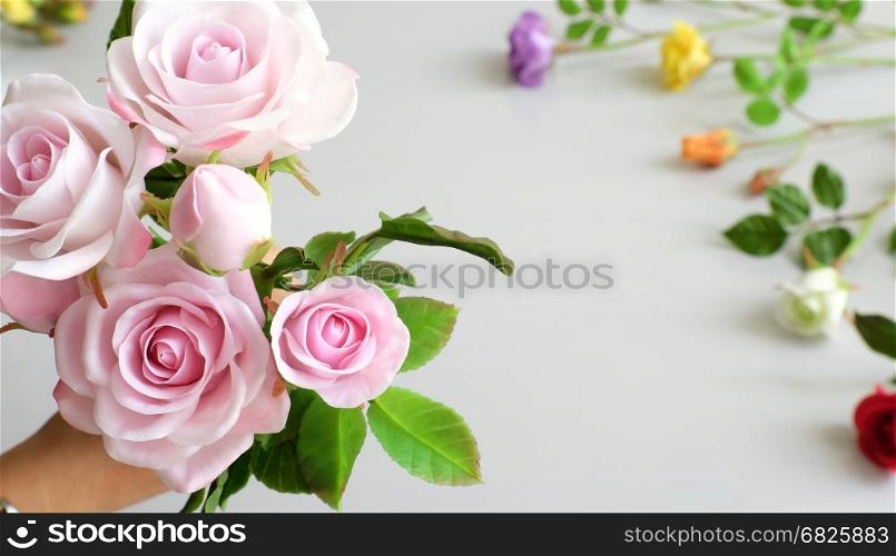 Wonderful clay art, woman hand hold bouquet of roses flower in pink on white background, beautiful artificial flowers of craftsmanship with skillful