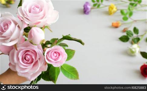 Wonderful clay art, woman hand hold bouquet of roses flower in pink on white background, beautiful artificial flowers of craftsmanship with skillful