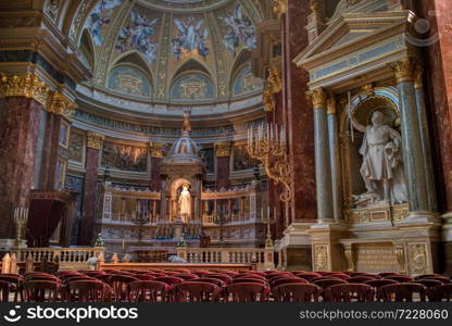 Wonderful interior of Catholic Cathedral with colorful painting on the walls and marble statues and sculptures in Budapest, Hungary.. Beautiful interior of Catholic Cathedral with painting and sculptures, Budapest.