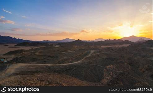 Wonderful landscape,Arabian desert of stone, Egypt with mountains at sunset.To the left of the desert nomad huts,
