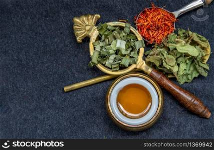 Wonderful Thai herbal tea with Dried pandan herb, indian marsh fleabane and safflower with honey on spoons. Selective focus.