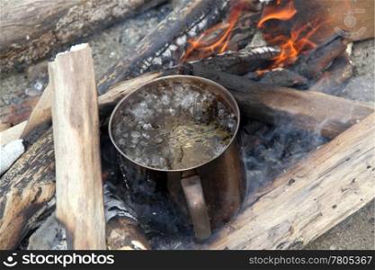 wood and boiling water in camp fire, camping