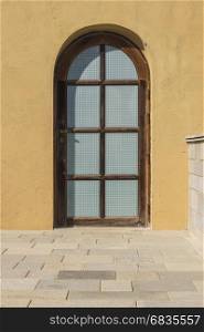 wood arched window with rough plaster wall