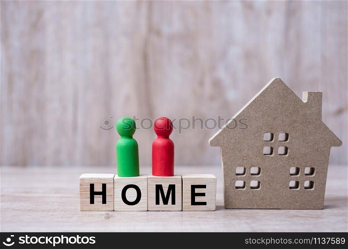 Wood block with HOME text and house model on wooden background. Banking, real estate, Property investment, home mortgage, financial and savings concepts