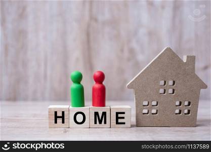 Wood block with HOME text and house model on wooden background. Banking, real estate, Property investment, home mortgage, financial and savings concepts
