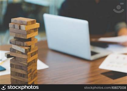 wood blocks stack game with background of businessman working in office