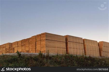 Wood boards stacked outdoor. Industrial amount of timber planks at a german wood-working factory