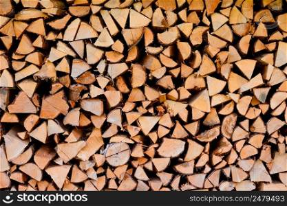 Wood logs firewood big chopped trunks stacked pile dry for winter fireplace texture background