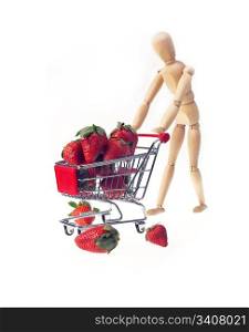 wood mannequin carriyng strawberries on shopping cart over white