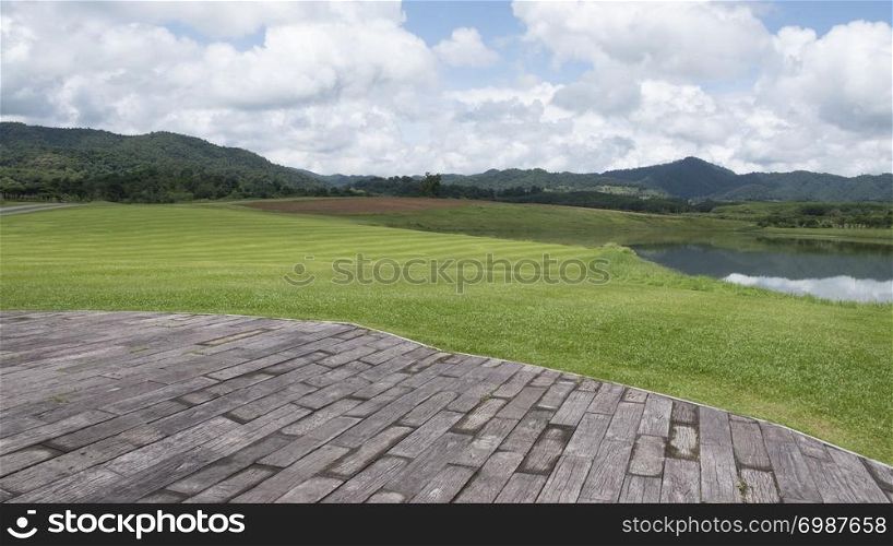 Wood old table against landscape mountain and cloud sky background with focus to the table top in the foreground