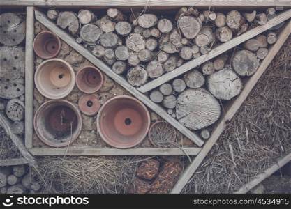 Wood on a shelf in a woodshed with pots and hay