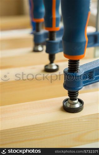 wood pasting by clamps in a joiner&rsquo;s workshop, close-up photo