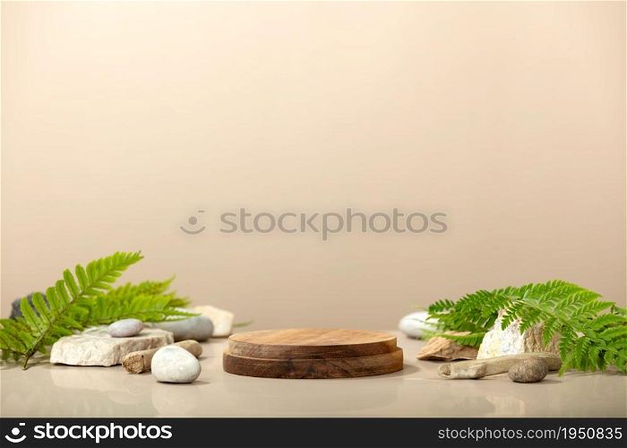 Wood podium with green leaves and natural stones. Abstract podium for organic cosmetic products. Natural stand for presentation and exhibitions. Front view