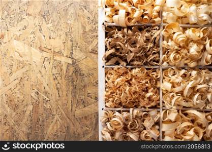 Wood shavings in box on table background. Wooden shaving at old plank board texture