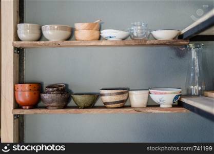 Wood shelf with ceramic bowl and cup closeup