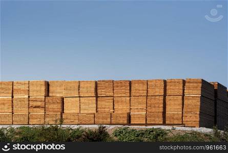 Wood stock outdoor. Stacks of timber planks. Wood industry in Germany