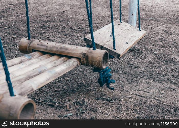 wood swing hanging on tree in park outdoors