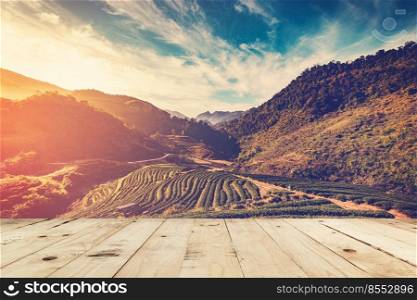 wood table and tea field and sunrise vintage in morning