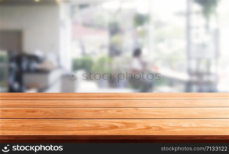 Wood table in blurry background of modern restaurant room or coffee shop with empty copy space on the table for product display mockup. Interior restaurant counter design concept.