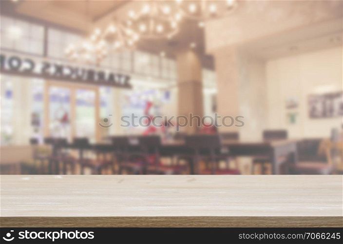wood table top and Abstract Blurred coffee shop or cafe restaurant . Can be used for display or montage your products.