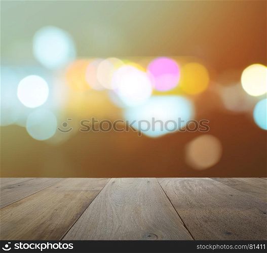 wood table top on abstract background with bokeh defocused lights and shadow from cityscape at night, vintage or retro color tone