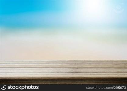 Wood table top on blurred beach background, summer concept - can be used for display your products.